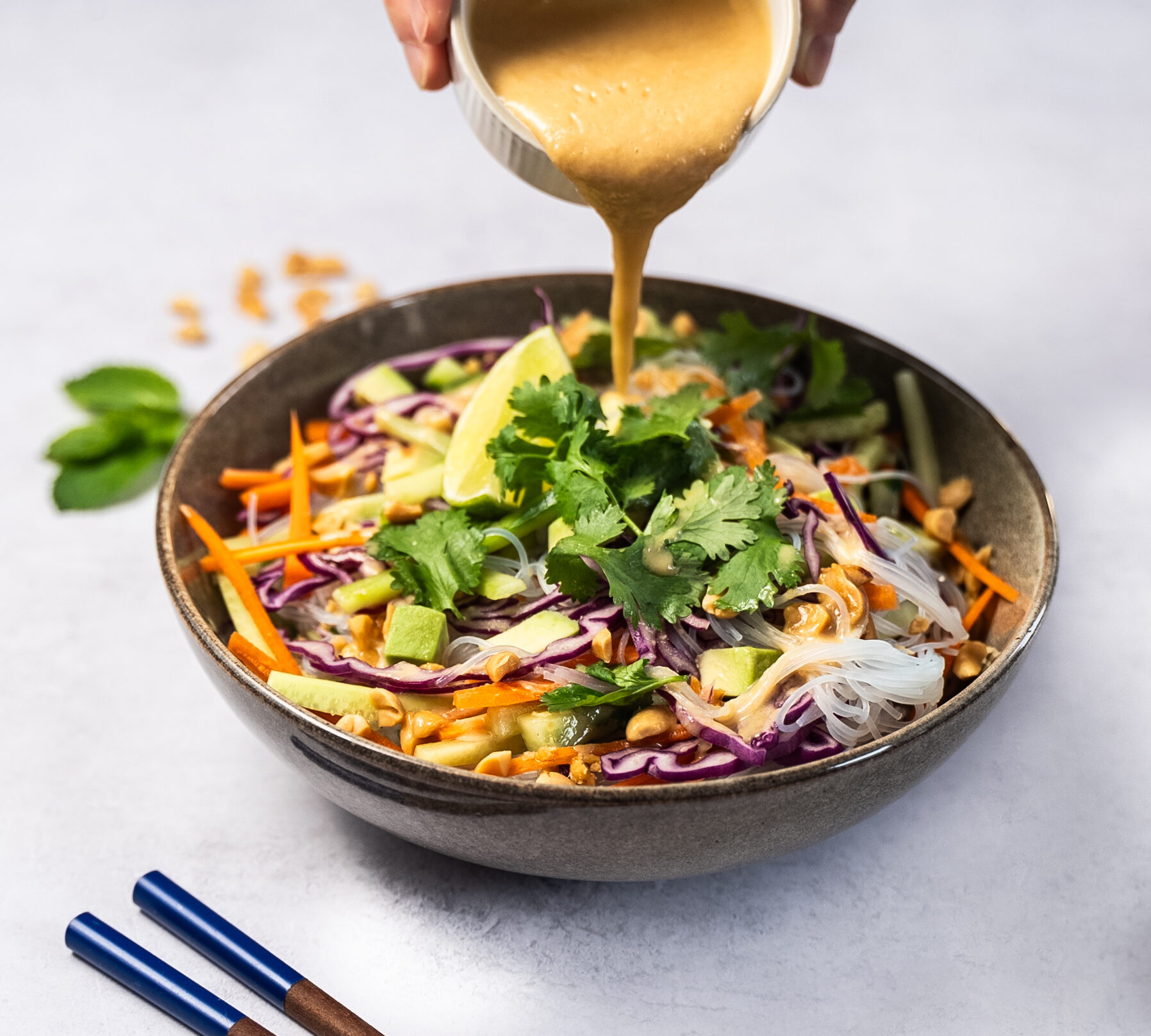 Sauce cacahuète versée sur salade asiatique aux cacahuètes Menguy's