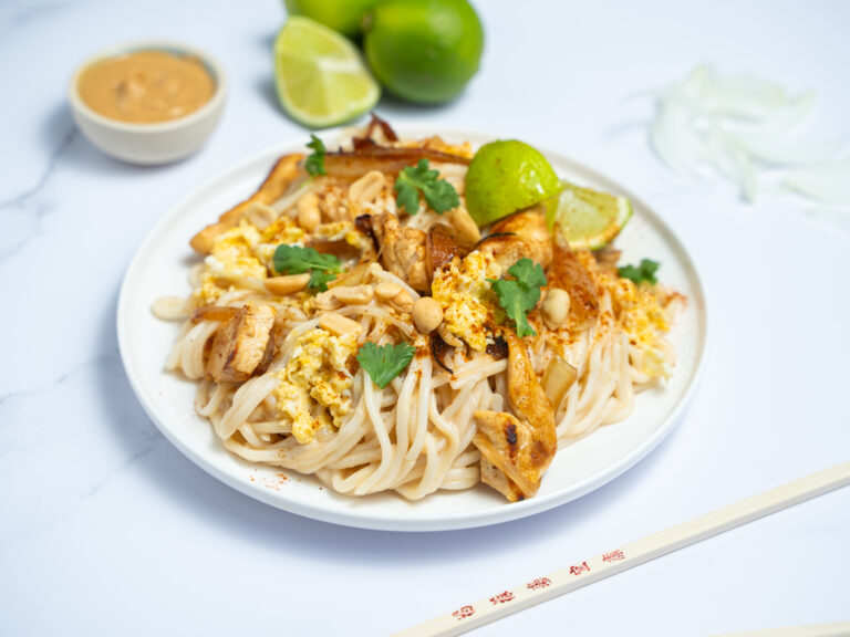 Nouilles sautées au poulet, œufs, cacahuètes et citron vert