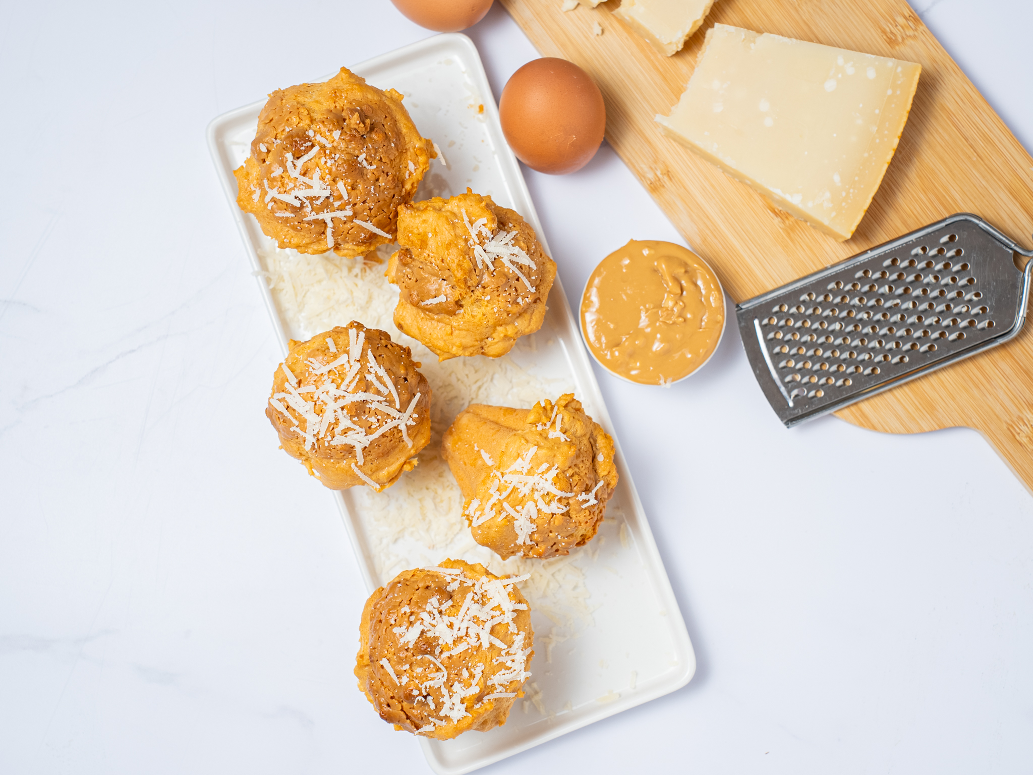 Gougères au fromage pour Apéro, parsemées de fromage râpé