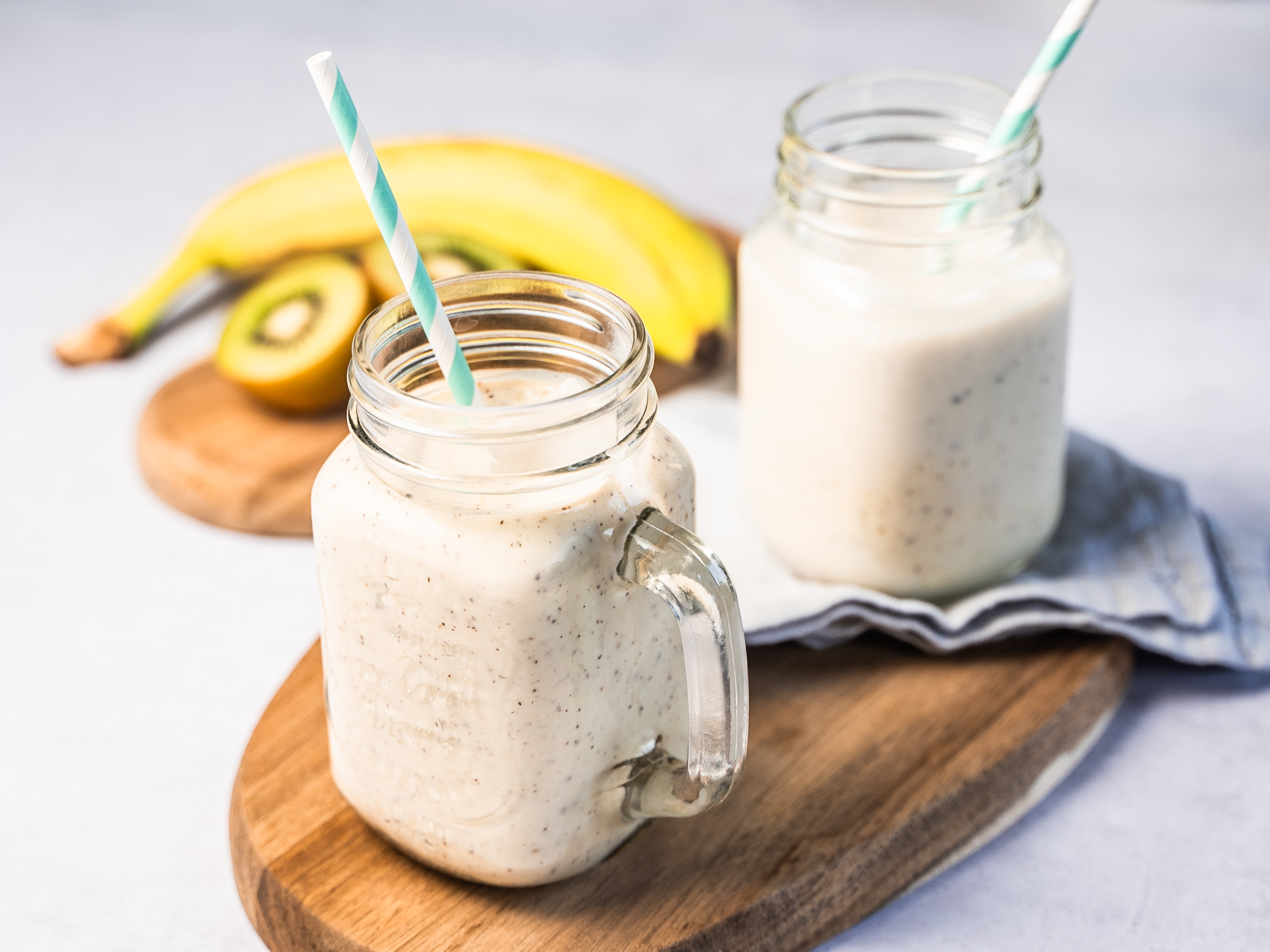 Smoothies banane kiwi dans des bocaux en verre avec paille