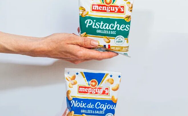 Main tenant des sachets Menguy's de pistaches et noix de cajou Apéro