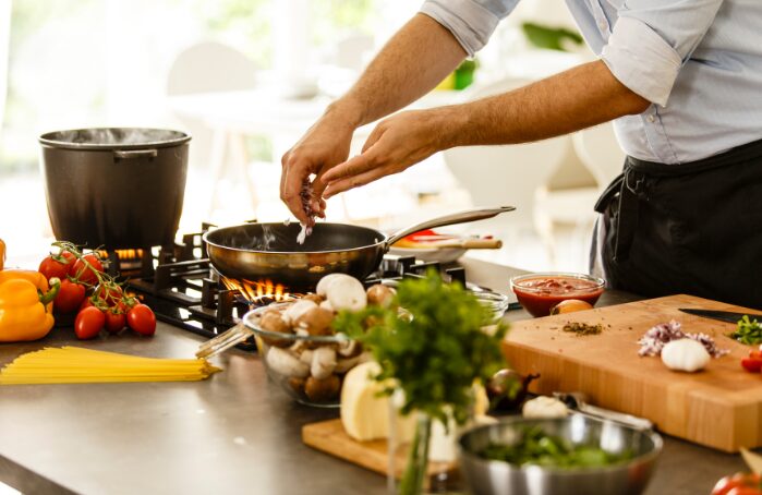 Personne cuisinant des pâtes à l’Apéro dans une poêle