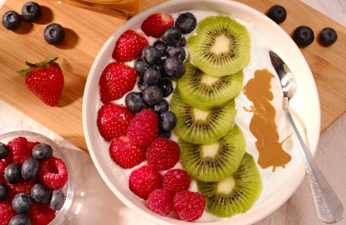 Bol de yaourt aux fraises, myrtilles, framboises, kiwi et caramel