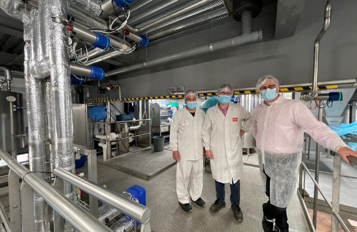 Trois personnes en tenue sanitaire dans l'usine Menguy's Apéro