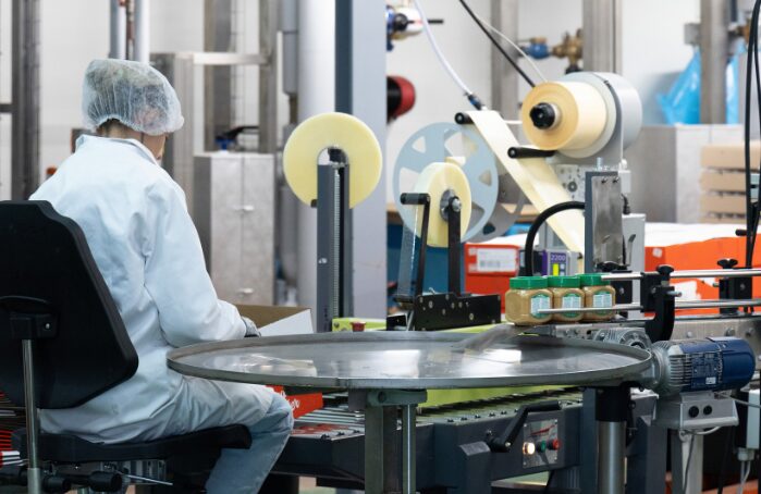 Opérateur en usine Menguy's supervisant l'emballage de produits Apéro